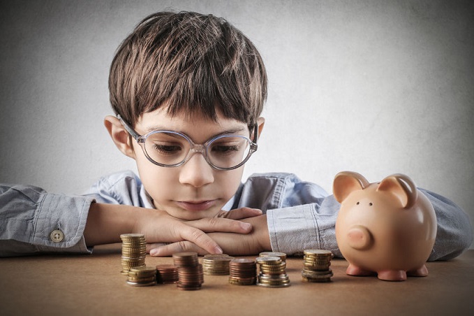 Un niño observa el dinero ahorrado.