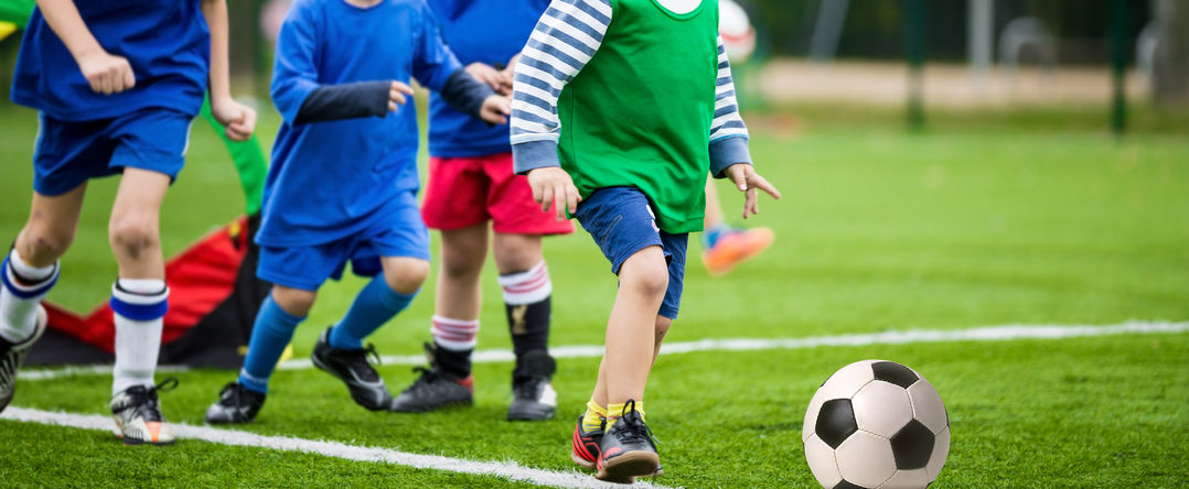 Unos niños juegan en un campus de fútbol.