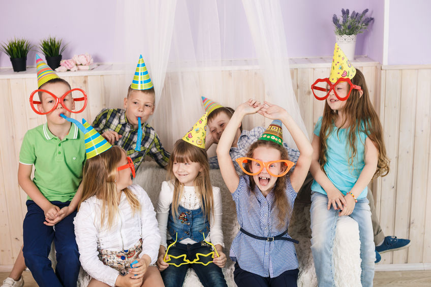Varios niños celebran divertidos un cumpleaños.