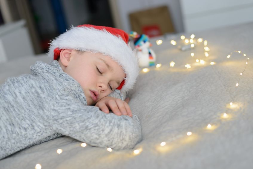 Un niño dormido por el cansancio en Navidad.