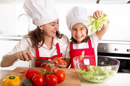 Una niña ayuda a su madre en la cocina.