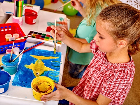 Una niña en una actividad extraescolar de pintura.