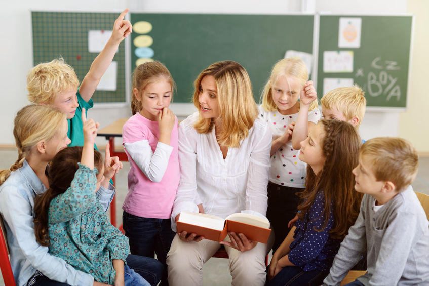 Niños que trabajan en grupo con el profesor en clase