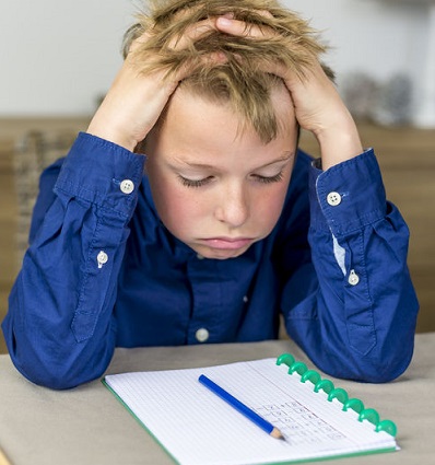 Un niño estresado ante las tareas del colegio.