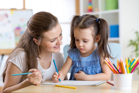 Una madre ayuda a su hija con una tarea escolar.
