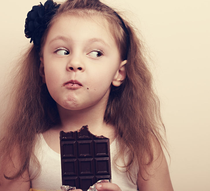 Niña comiendo chocolate en exceso