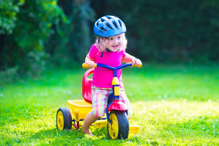 Niña montando en triciclo sola y con casco