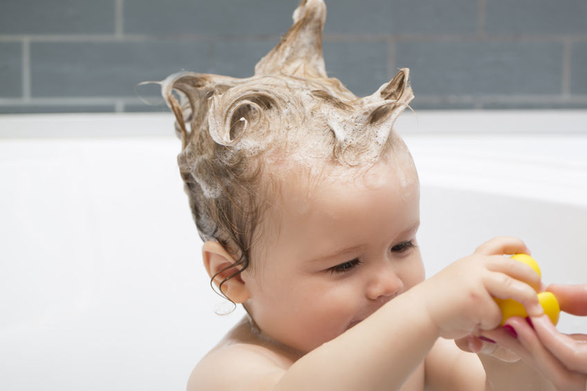 Bebé en la bañera con pelo enjabonado