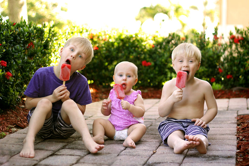 Niños comen polos de fruta muy alegres