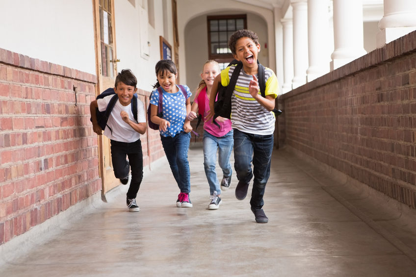 Niños corriendo por el pasillo del colegio