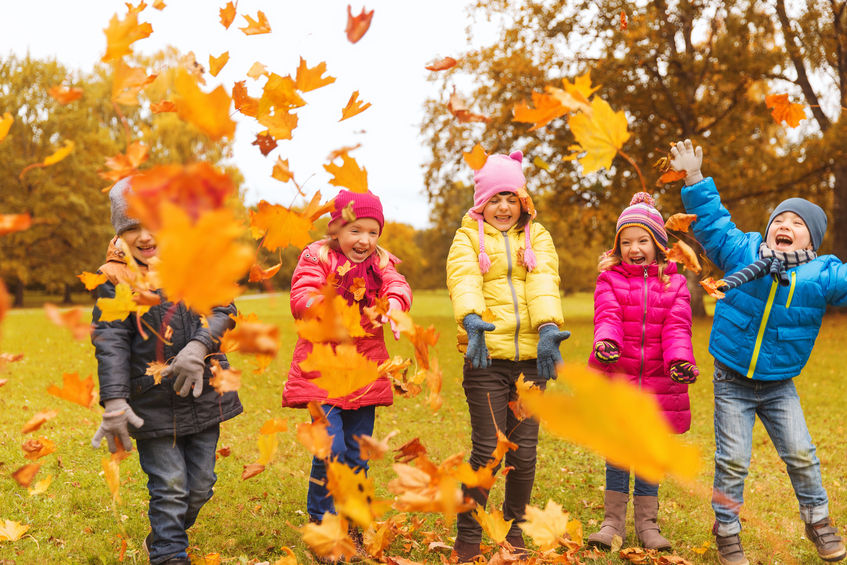 Niños que juegan solos en el parque en otoño