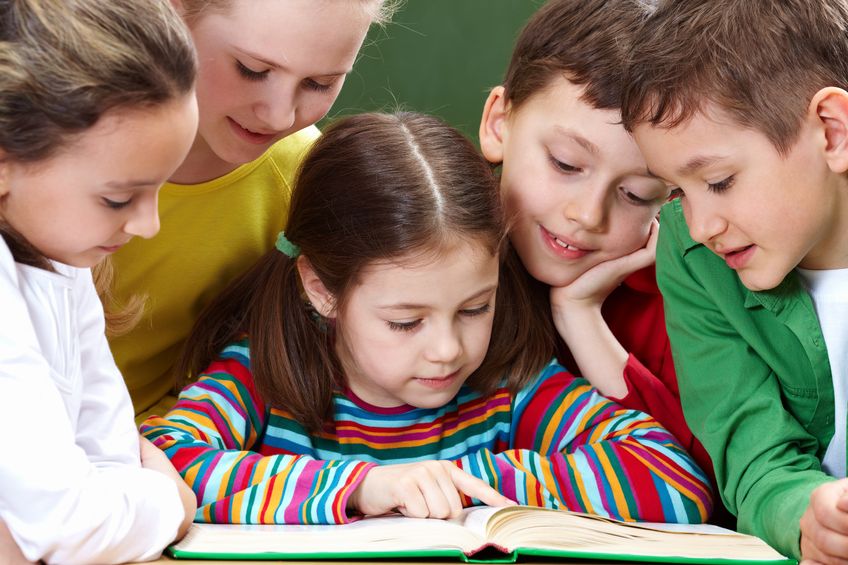 Niños leen y trabajan en grupo en clase