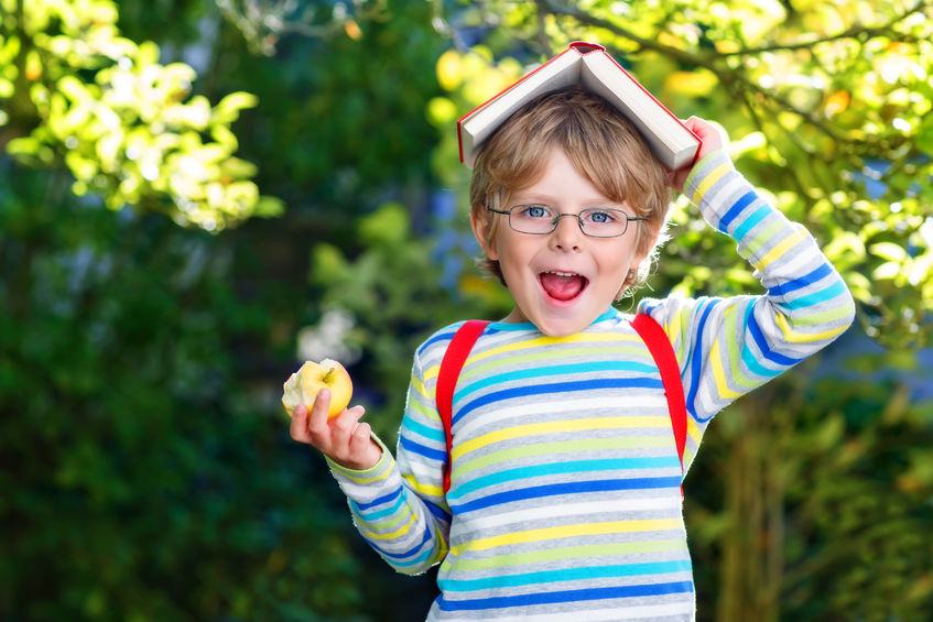 Un niño come una manzana entre horas.